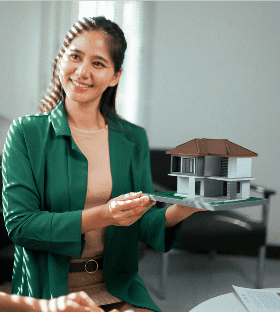 Woman holding house model, smiling