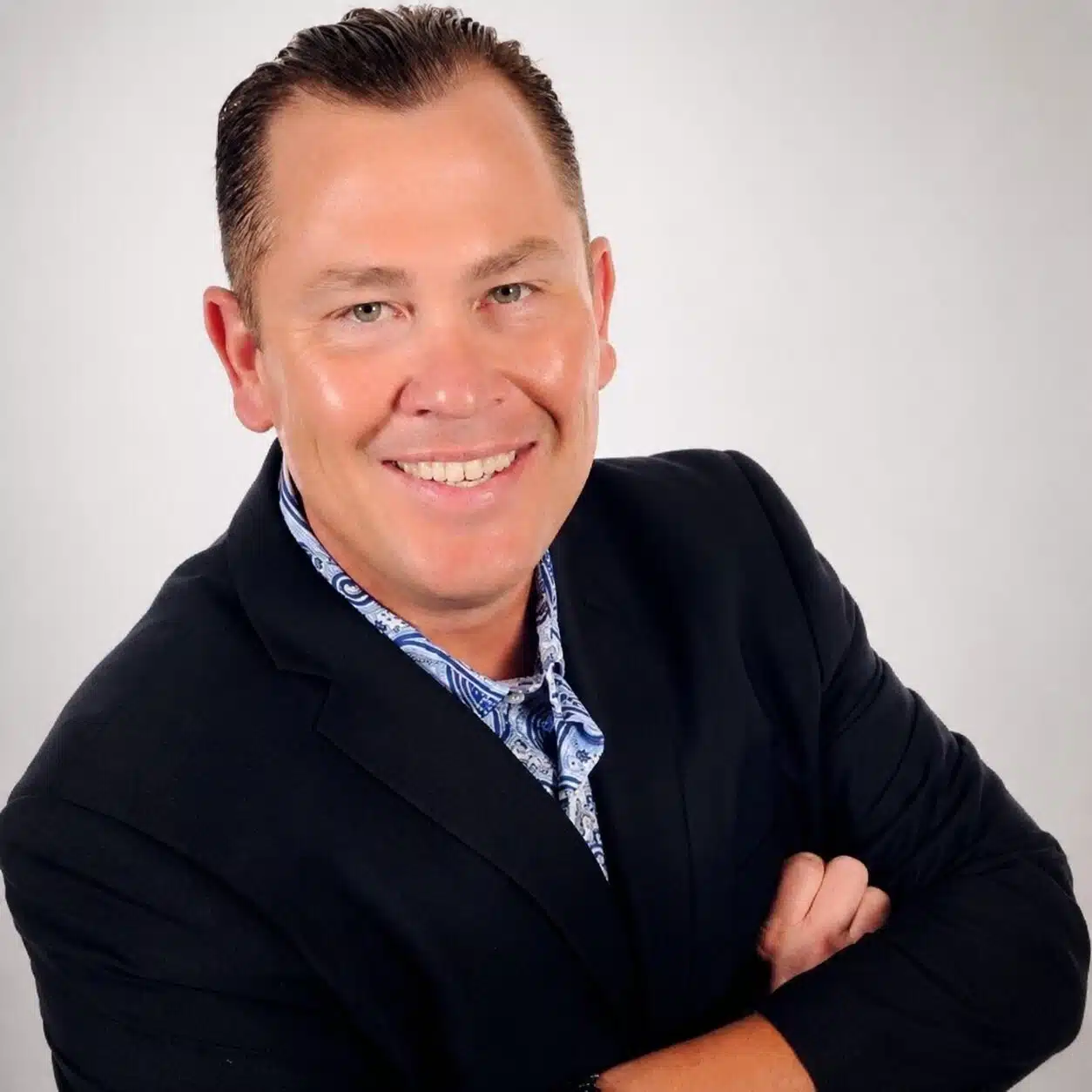 Smiling man in blazer with folded arms